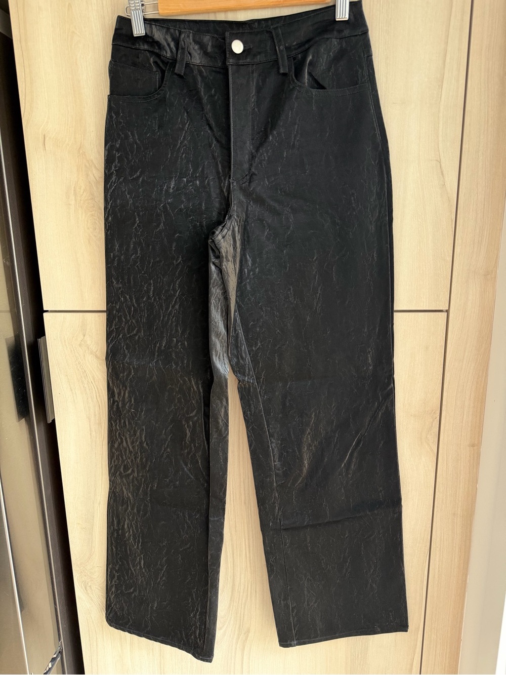 Black straight-leg pants satin-like sheen and a crinkled texture